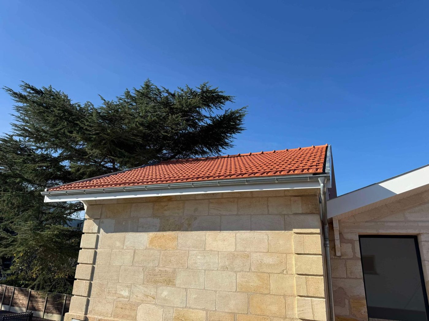 Couverture neuve en tuiles terre cuite et zinguerie sur une maison en pierre, réalisée par A2Roulet-Toiture à Mérignac
